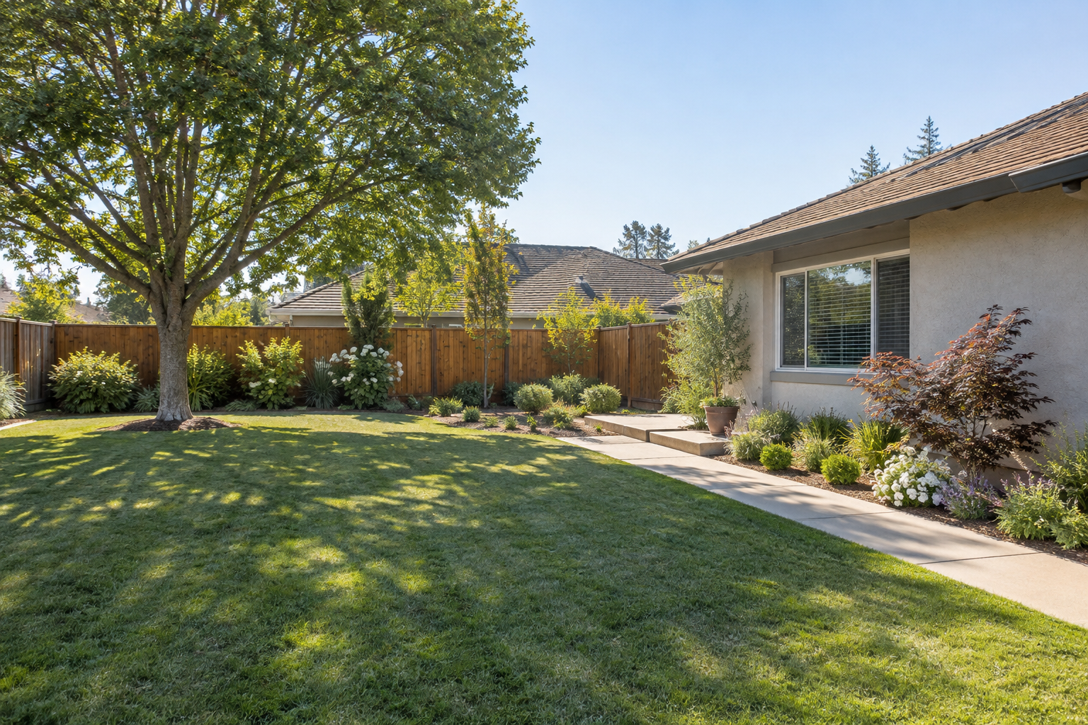 Fresno residential landscape combining lawn, planting, shade tree, walkway and cedar fence